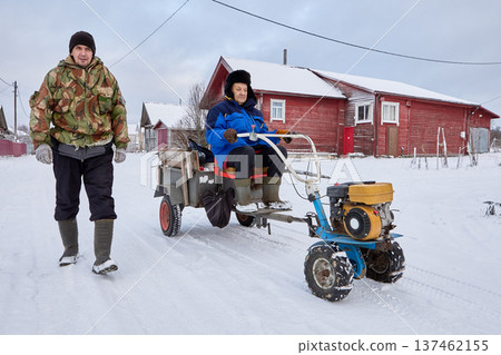 Power tiller with trailer serves as transport vehicle for two farmers during winter period. Power tiller with trailer serves as transport vehicle for two farmers during winter period. 137462155