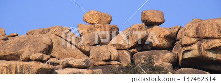 Big balancing granite boulders on a mountain ridge in Basapur, Hampi, India. Big balancing granite boulders on a mountain ridge in Basapur, Hampi, India. 137462314
