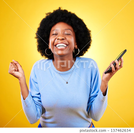 Woman, phone and fist for success in studio, celebration and winning lottery prize, promotion or bonus on yellow background. Happy african model, mobile app and celebrate online gambling achievement Woman, phone and fist for success in studio, celebration and winning lottery prize, promotion or bonus on yellow background. Happy african model, mobile app and celebrate online gambling achievement 137462634