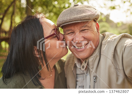 Selfie, kiss and senior couple in a park happy, bond and having fun in nature together. Portrait, love and elderly man with old woman in forest smile for profile picture, kissing and enjoy retirement 137462807