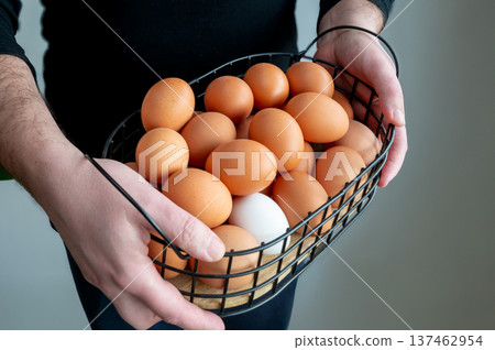 Farmer Carrying Metal Basket of Organic Eggs Farmer Carrying Metal Basket of Organic Eggs 137462954