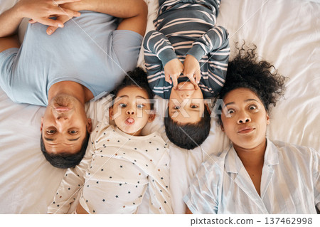 Happy, funny face and portrait with family in bedroom for playful, morning and love. Care, support and wake up with parents and children from above in bed at home for weekend, positive or relax Happy, funny face and portrait with family in bedroom for playful, morning and love. Care, support and wake up with parents and children from above in bed at home for weekend, positive or relax 137462998