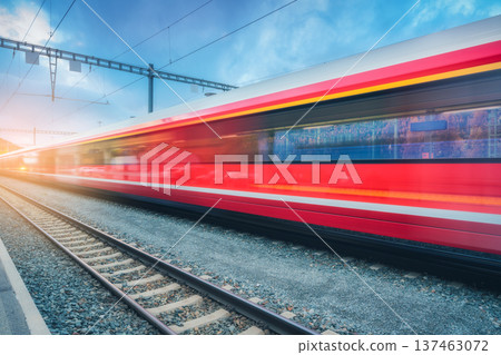 Blurred red passenger train passing mountain railway station 137463072