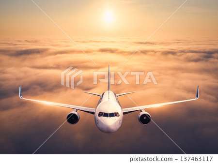 Front view of commercial passenger airplane flying above clouds Front view of commercial passenger airplane flying above clouds 137463117