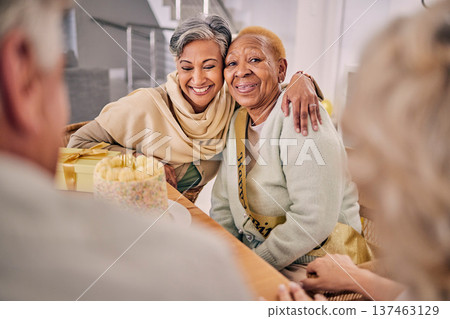 Happy, smile and senior friends hugging at a birthday party, celebration or event at retirement home. Excited, bonding and elderly women embracing with love, care and happiness in a modern house. Happy, smile and senior friends hugging at a birthday party, celebration or event at retirement home. Excited, bonding and elderly women embracing with love, care and happiness in a modern house. 137463129