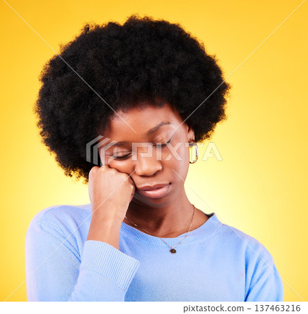 Tired, black woman and hand on face in studio looking sad, fatigue and burnout of depression and mental health. Exhausted, person and stress with crisis, anxiety and problem on yellow background Tired, black woman and hand on face in studio looking sad, fatigue and burnout of depression and mental health. Exhausted, person and stress with crisis, anxiety and problem on yellow background 137463216