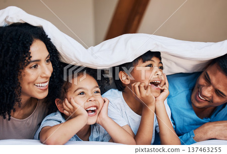 Happy, smile and children with their parents by a blanket on a bed together for bonding or connection. Happiness, love and young family from Colombia relaxing in the room of their modern house. Happy, smile and children with their parents by a blanket on a bed together for bonding or connection. Happiness, love and young family from Colombia relaxing in the room of their modern house. 137463255