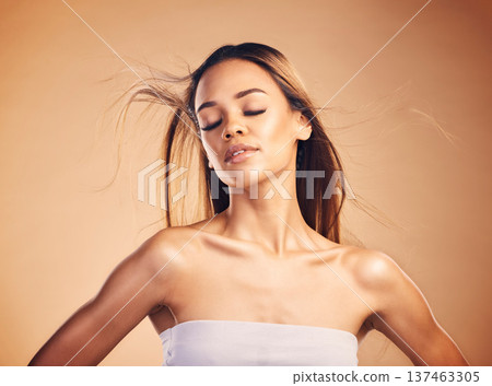 Beauty, hair and wind with a natural model in studio on a brown background for keratin treatment. Skin, shampoo and body with a confident young woman at the salon for growth or aesthetic haircare 137463305