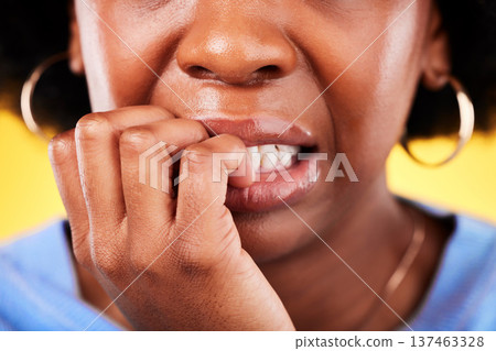 Closeup, woman and biting hands in anxiety, nervous or mental health disorder against a yellow background. Mouth of anxious female person in stress, breakdown or issues and problems in bad habit 137463328