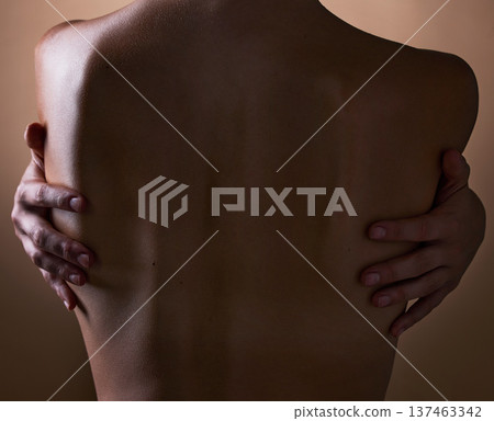 Woman, back and hands touching body on brown background in studio for creative aesthetic, art deco and skin texture. Person, dark and shadow of model in self love hug for nude and sensual wellness 137463342