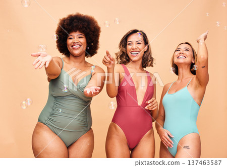 Fun, women and bikini with bubbles on studio background for happiness, playing or bonding. Inclusion, diversity and playful friends or model with freedom and swimwear for summer together on backdrop 137463587