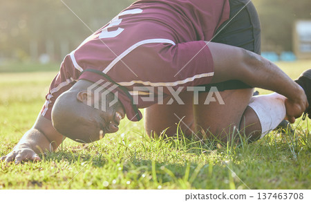 Sports, field injury and a black man during soccer with an emergency in fitness or training. Grass, pain and an African football player or athlete on the ground during a game with an accident 137463708