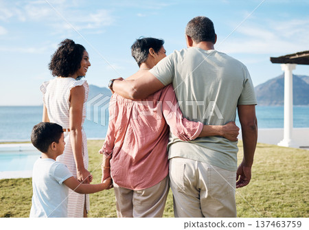 Back, summer and vacation by the sea with family outdoor together looking at a view of nature. Grandparents, mother and happy son by the ocean for love, holiday freedom or weekend getaway and travel 137463759