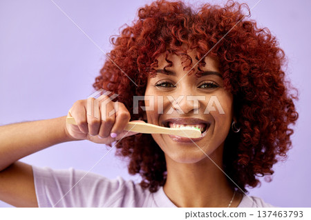 Face, smile and woman brushing teeth with wood in studio isolated on purple background. Portrait, bamboo toothbrush and happy person cleaning for eco friendly hygiene, dental health or sustainability Face, smile and woman brushing teeth with wood in studio isolated on purple background. Portrait, bamboo toothbrush and happy person cleaning for eco friendly hygiene, dental health or sustainability 137463793