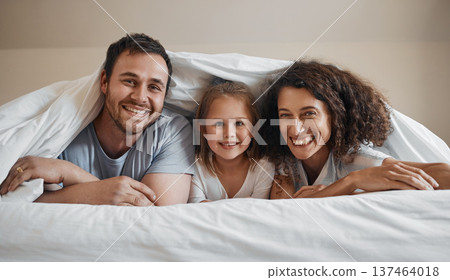 Smile, love and portrait of family in bed for bonding, relaxing and resting together with blanket. Happy, excited and young girl child laying with her mother and father in the bedroom of modern home. Smile, love and portrait of family in bed for bonding, relaxing and resting together with blanket. Happy, excited and young girl child laying with her mother and father in the bedroom of modern home. 137464018
