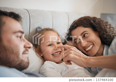 Family, bed and parents playing with their daughter in the morning to relax after waking up together. Kids, love or smile with a man, woman and cute nose of a child joking in the bedroom closeup Family, bed and parents playing with their daughter in the morning to relax after waking up together. Kids, love or smile with a man, woman and cute nose of a child joking in the bedroom closeup 137464100
