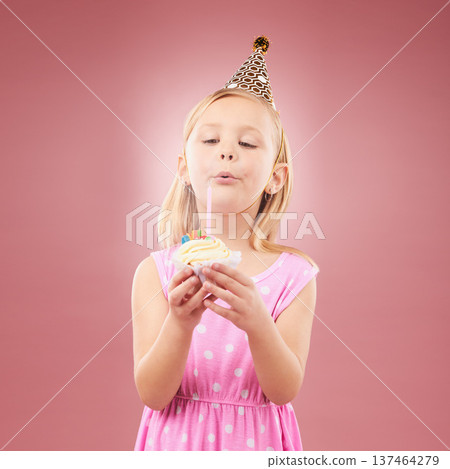 Blow candle, birthday and child with cupcake for holiday party, happy celebration and a wish. Young girl kid on a pink background for surprise, cake or celebrate achievement with a dessert and joy Blow candle, birthday and child with cupcake for holiday party, happy celebration and a wish. Young girl kid on a pink background for surprise, cake or celebrate achievement with a dessert and joy 137464279