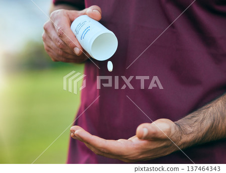 Pill box, medicine and man hand closeup of a sport on a soccer field with tablet and drugs for health. Supplements, container and outdoor with an athlete holding wellness and paracetamol medication 137464343