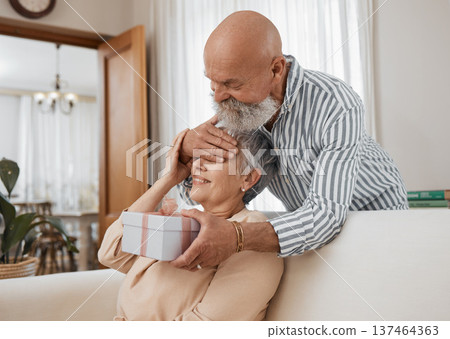 Senior couple, gift and sofa with eyes covered for surprise, anniversary or birthday in home living room. Elderly man, woman and present in box for celebration, marriage or party with love on couch Senior couple, gift and sofa with eyes covered for surprise, anniversary or birthday in home living room. Elderly man, woman and present in box for celebration, marriage or party with love on couch 137464363