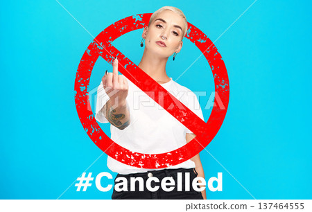 Portrait, rude and cancel culture with a woman on a blue background in studio to reject or deny an icon. Social media, hashtag and censorship with a rebel girl showing a hand gesture in protest Portrait, rude and cancel culture with a woman on a blue background in studio to reject or deny an icon. Social media, hashtag and censorship with a rebel girl showing a hand gesture in protest 137464555