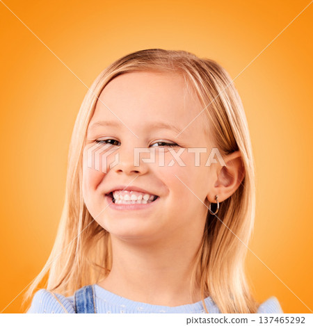 Happy, smile and portrait of girl on orange background with happiness, joy and excited in studio. Canada, childhood and face of young, confident and cute child relax with smile for positive attitude 137465292
