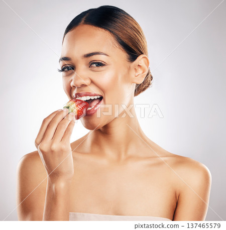 Woman, eating strawberry and beauty portrait, skincare or eco friendly product, color choice and dermatology in studio. Person, red fruit and vegan makeup, lipstick or cosmetics on a white background Woman, eating strawberry and beauty portrait, skincare or eco friendly product, color choice and dermatology in studio. Person, red fruit and vegan makeup, lipstick or cosmetics on a white background 137465579