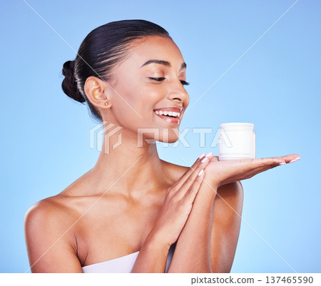 Skincare, cream and product with woman and jar in studio for beauty, facial or moisturizer. Spa treatment, health and collagen with face of person on blue background for makeup, glow or sunscreen Skincare, cream and product with woman and jar in studio for beauty, facial or moisturizer. Spa treatment, health and collagen with face of person on blue background for makeup, glow or sunscreen 137465590