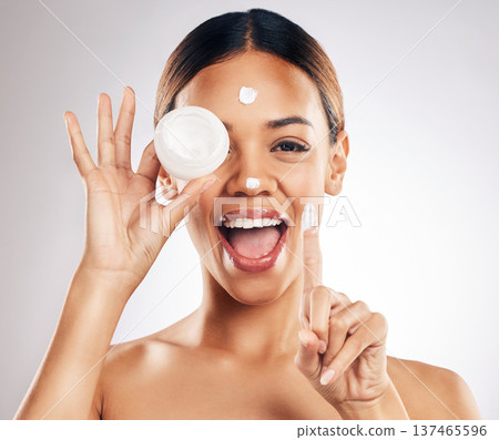 Woman, cream container and hands for eye skincare, beauty or cosmetics application on a white background. Excited person in happy portrait for collagen, moisturizer and dermatology health in studio Woman, cream container and hands for eye skincare, beauty or cosmetics application on a white background. Excited person in happy portrait for collagen, moisturizer and dermatology health in studio 137465596