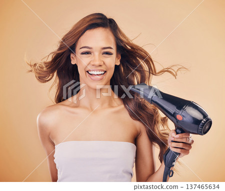 Hair dryer, portrait and a woman in studio for beauty, cosmetics and shine. Aesthetic model person on brown background for heat treatment, healthy results and hairdresser or salon blowing product Hair dryer, portrait and a woman in studio for beauty, cosmetics and shine. Aesthetic model person on brown background for heat treatment, healthy results and hairdresser or salon blowing product 137465634