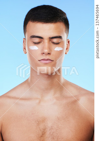 Self care, skincare or man with face cream product for beauty or natural moisturizer or cosmetics in studio. Blue background, eyes closed or model with facial creme or dermatology lotion for glow 137465694