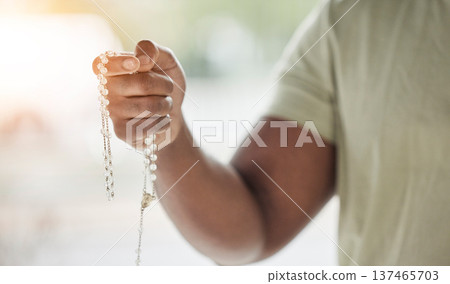 Rosary, man hand and faith with prayer beads in home with hope, christian praise and religion. Praying, necklace and worship in house with hope, gratitude and spiritual guide for support and healing Rosary, man hand and faith with prayer beads in home with hope, christian praise and religion. Praying, necklace and worship in house with hope, gratitude and spiritual guide for support and healing 137465703