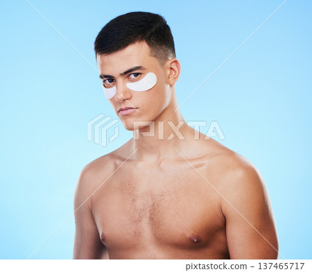 Man, beauty and portrait with eye patch for skincare, grooming and clean with hygiene on blue background. Skin treatment, cosmetics product and wellness, self care and dermatology in a studio 137465717