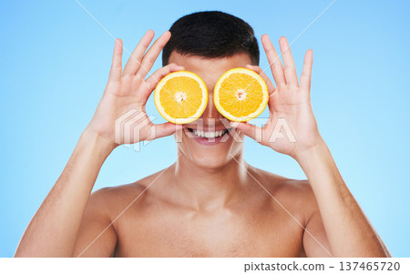 Happy, lemon and skincare with face of man in studio for health, detox and natural cosmetics. Vitamin c, nutrition and summer with person and fruit on blue background for self care, beauty and glow Happy, lemon and skincare with face of man in studio for health, detox and natural cosmetics. Vitamin c, nutrition and summer with person and fruit on blue background for self care, beauty and glow 137465720