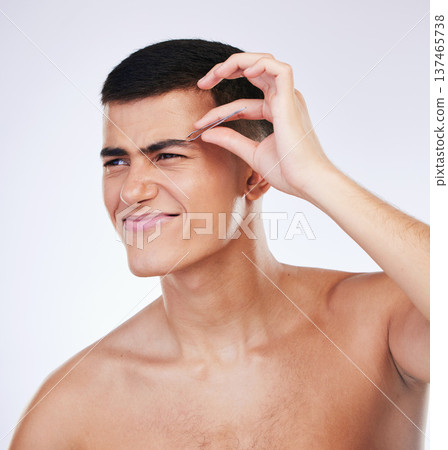 Man, tweezer and skincare with facial and beauty treatment for skin glow and wellness in studio. Male model, dermatology pain and hair removal tool for eyebrows pull and face with grey background 137465738