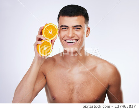 Skincare, orange and wellness with portrait of man in studio for health, detox and natural cosmetics. Vitamin c, nutrition and summer with face of person and fruit on white background for self care Skincare, orange and wellness with portrait of man in studio for health, detox and natural cosmetics. Vitamin c, nutrition and summer with face of person and fruit on white background for self care 137465837