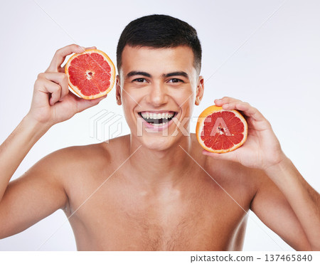 Beauty, grapefruit and natural with portrait of man in studio for health, detox or cosmetic. Vitamin c, nutrition and skincare with face of person and fruit on white background for self care and glow Beauty, grapefruit and natural with portrait of man in studio for health, detox or cosmetic. Vitamin c, nutrition and skincare with face of person and fruit on white background for self care and glow 137465840