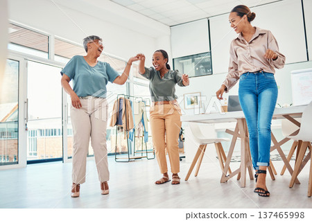 Women in creative office, dancing together and excited for achievement, success and small business sales goals. Celebration, diversity and happy employees at fun fashion design studio with smile. Women in creative office, dancing together and excited for achievement, success and small business sales goals. Celebration, diversity and happy employees at fun fashion design studio with smile. 137465998