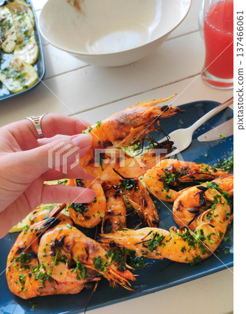 Hand holding grilled shrimp Hand holding grilled shrimp 137466061
