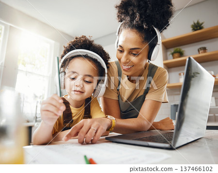 Elearning, mom and child in home with headphones, laptop and homework for online class. Computer, mother and boy working together for virtual school, help with writing and kids education in kitchen. Elearning, mom and child in home with headphones, laptop and homework for online class. Computer, mother and boy working together for virtual school, help with writing and kids education in kitchen. 137466102