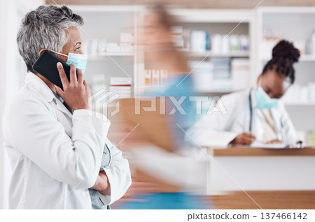 Woman, pharmacist and phone call with face mask in Telehealth, consultation or conversation at pharmacy. Female person or medical healthcare professional talking on mobile smartphone in online advice 137466142