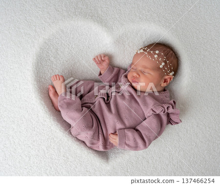 Sleeping newborn baby curled up in a natural pose on soft white background. Minimal newborn photography, calm atmosphere, early childhood and parental care concept 137466254