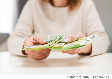 Female hands recounting euro banknotes. Savings, budgeting, income management, banking and financial security theme. 137466311