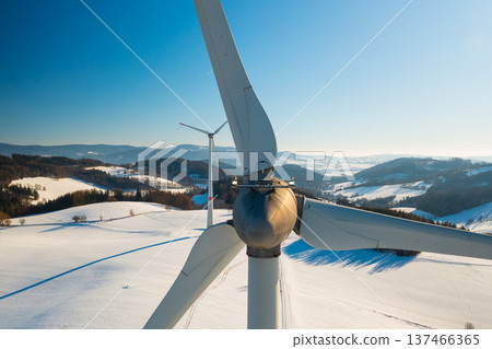 Wind turbine standing in a snowy open field during winter. Concept of reliable renewable energy and sustainable infrastructure. Wind turbine standing in a snowy open field during winter. Concept of reliable renewable energy and sustainable infrastructure. 137466365