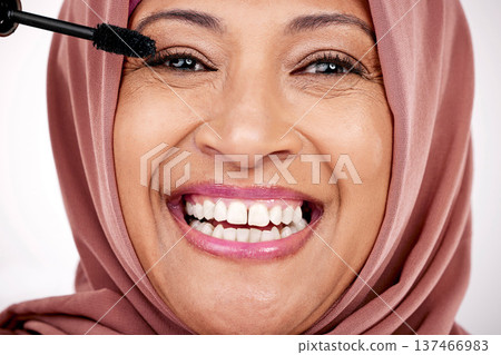 Portrait, mascara brush and woman in hijab for facial beauty, skincare and cosmetics in studio with smile. Face of happy mature muslim model with eye makeup product, application and tools for lashes. Portrait, mascara brush and woman in hijab for facial beauty, skincare and cosmetics in studio with smile. Face of happy mature muslim model with eye makeup product, application and tools for lashes. 137466983