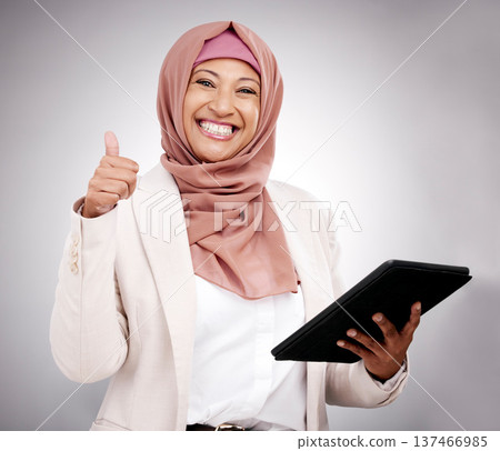 Thumbs up, tablet and portrait of a muslim woman in a studio doing research on the internet. Happy, smile and mature islamic female model with technology and agreement hand gesture by gray background 137466985