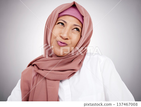 Smile, pouting and a Muslim woman on a studio background with hijab for happiness. Funny, thinking and a mature Islamic person or model with an expression for comedy, goofy or silly on a backdrop 137467008