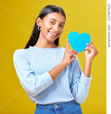 Portrait, donation and woman with blue heart in studio for help, hope or empathy on yellow background. Face, charity and social media, poster or thank you, support or autism or people with disability Portrait, donation and woman with blue heart in studio for help, hope or empathy on yellow background. Face, charity and social media, poster or thank you, support or autism or people with disability 137467025