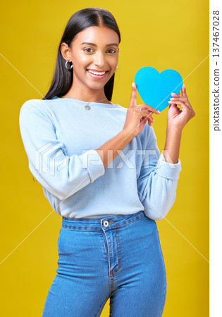 Portrait, smile and woman with blue heart in studio with help, hope or empathy on yellow background. Face, girl and social media icon for thank you, support and trust or people with loyalty to peace Portrait, smile and woman with blue heart in studio with help, hope or empathy on yellow background. Face, girl and social media icon for thank you, support and trust or people with loyalty to peace 137467028