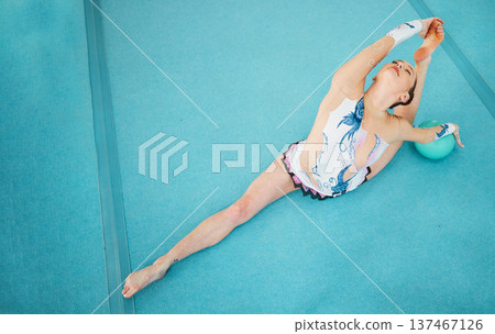 Woman, ball and split for gymnastics, sports competition or showcase solo concert from above with mockup space. Flexible dancer, rhythm performance or agile athlete stretching on floor in event arena 137467126