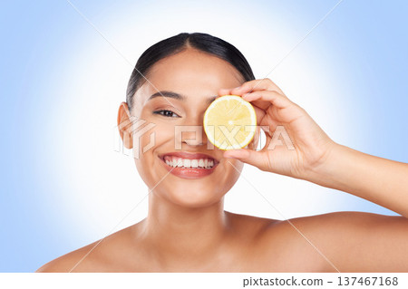Skincare, studio portrait and happy woman with lemon for organic detox treatment, natural self care routine or facial cleaning. Vitamin C benefits, fruit and face of person smile on blue background 137467168